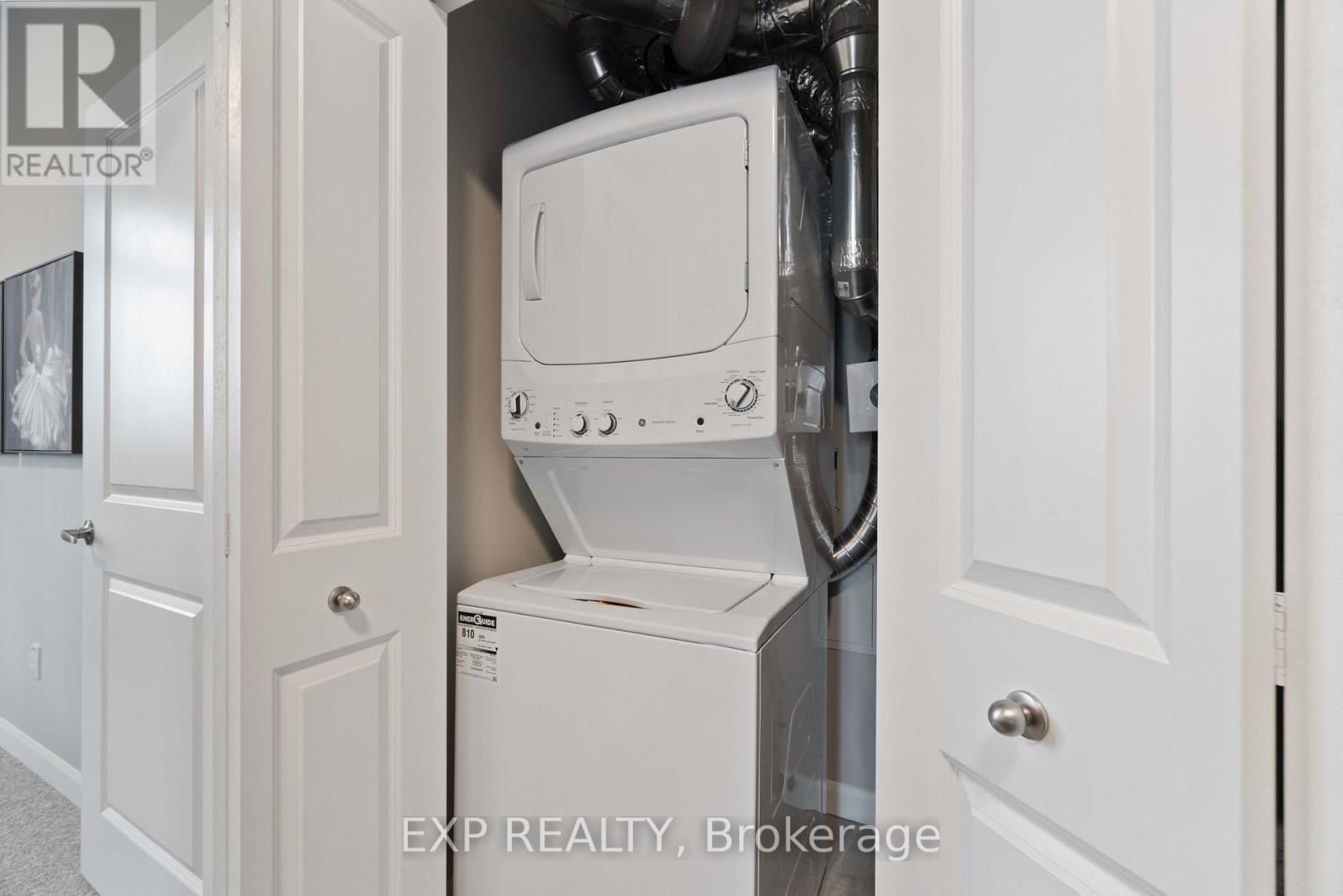 A white washing machine is in a small space between two doors.