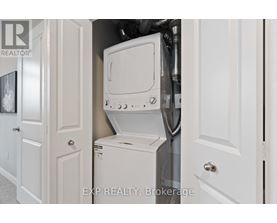 A white washing machine is in a small space between two doors.