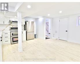 A spacious kitchen with white cabinets and a stainless steel refrigerator.