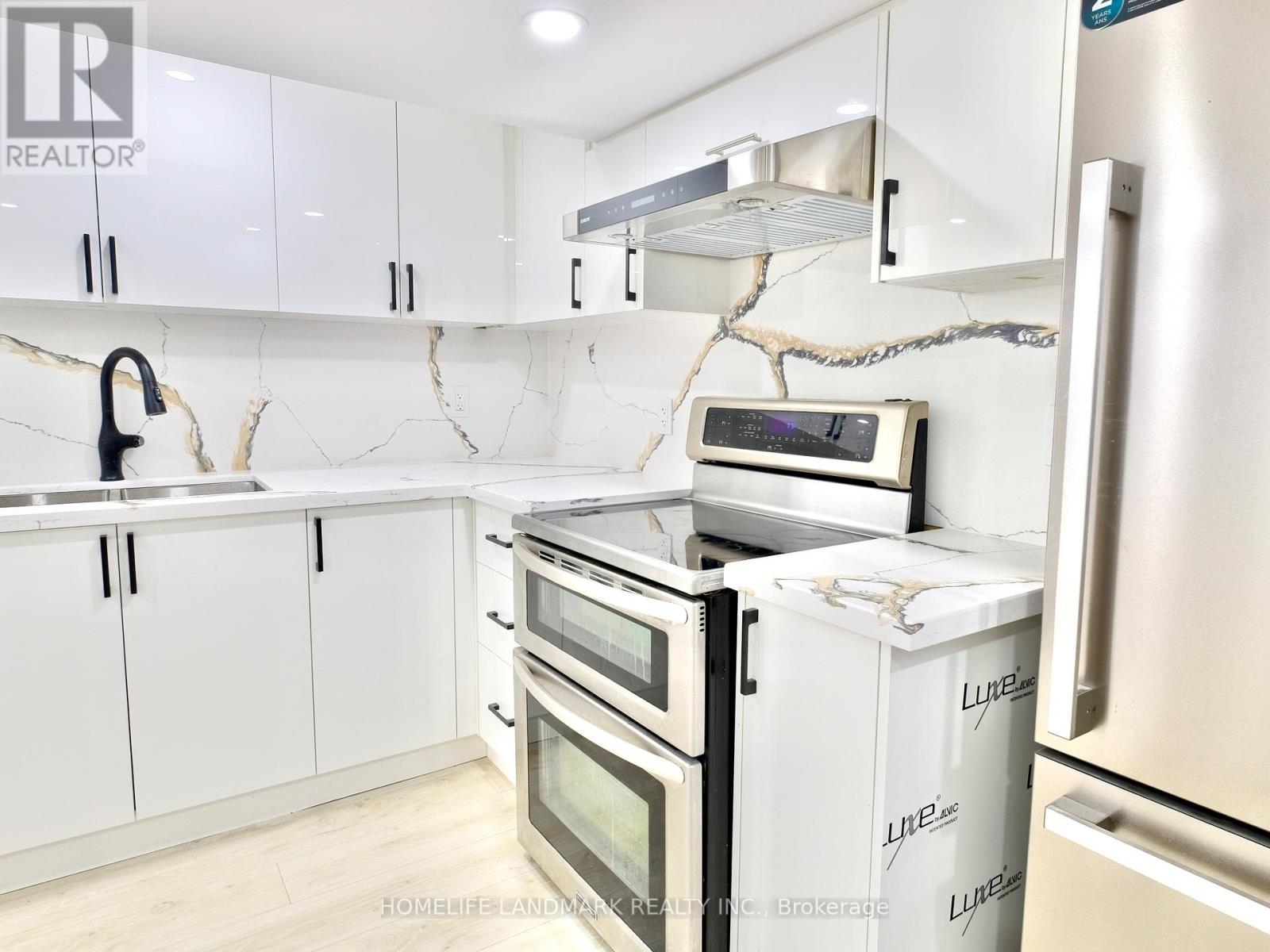 A kitchen with white cabinets and appliances, including a refrigerator, oven, and microwave.