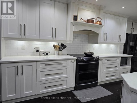 A kitchen with white cabinets and a black stove top oven.