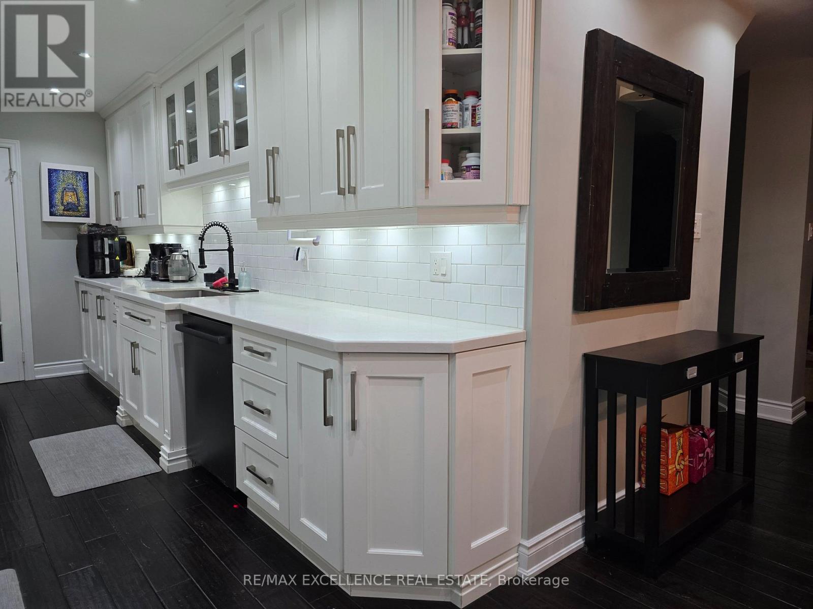 A kitchen with white cabinets and a black counter.