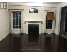 A living room with a fireplace and two windows.