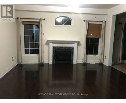 A living room with a fireplace and two windows.