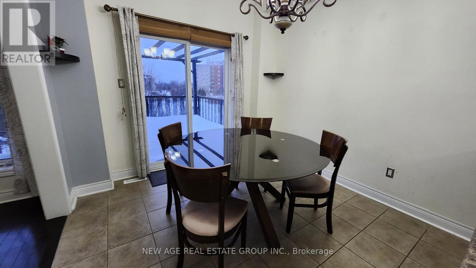 A dining room with a table and chairs and a view of a snowy landscape outside.