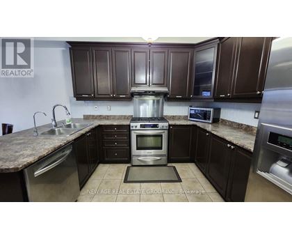 A kitchen with brown cabinets and a granite countertop.