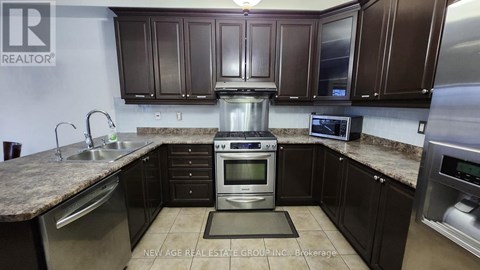 A kitchen with brown cabinets and a granite countertop.