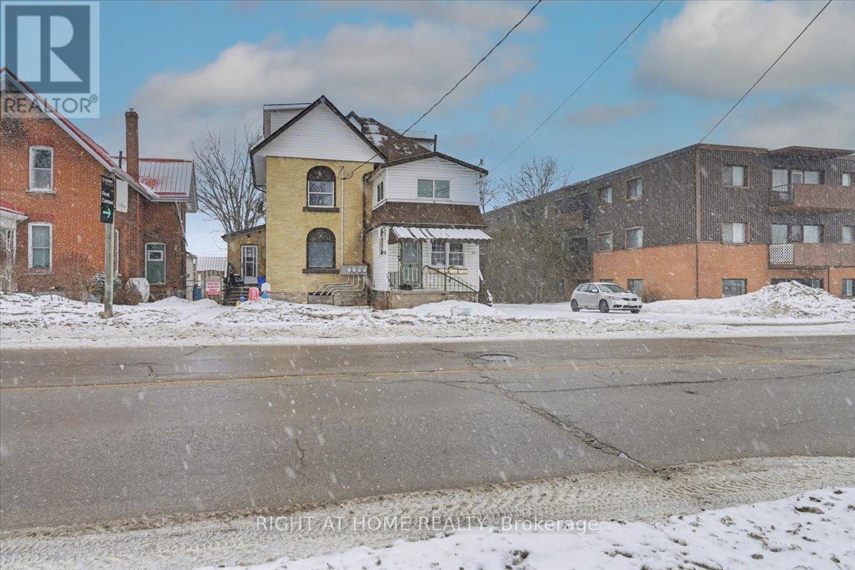 A snowy street with a house and a car.