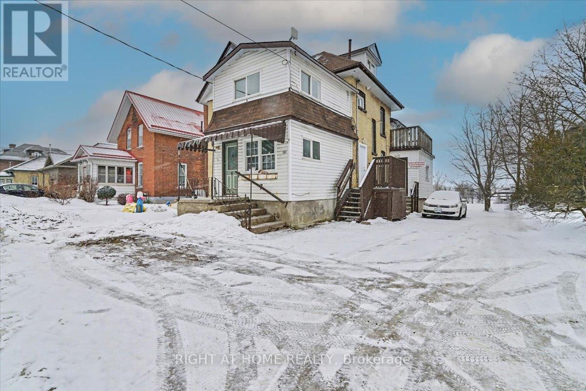A snow-covered street with a house and a car parked in front.