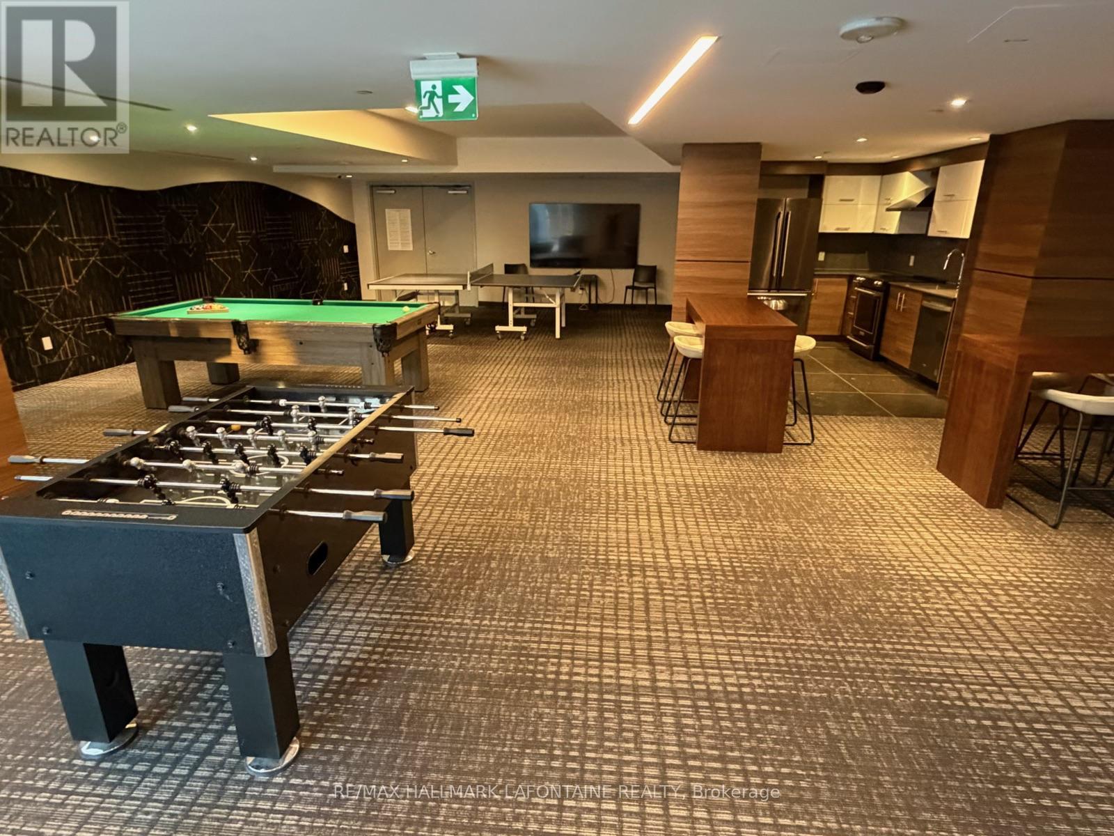 A room with a pool table and a foosball table.