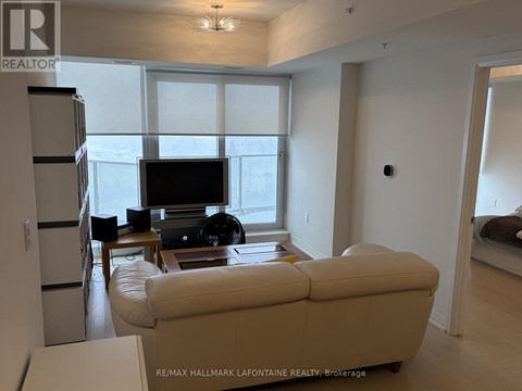 A living room with a white couch and a television.
