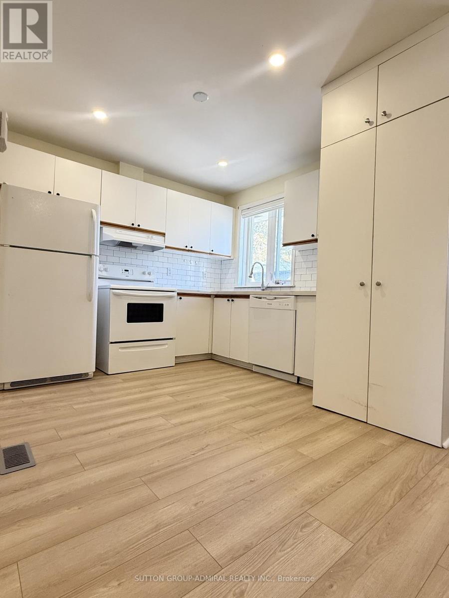 A kitchen with white appliances and cabinets.
