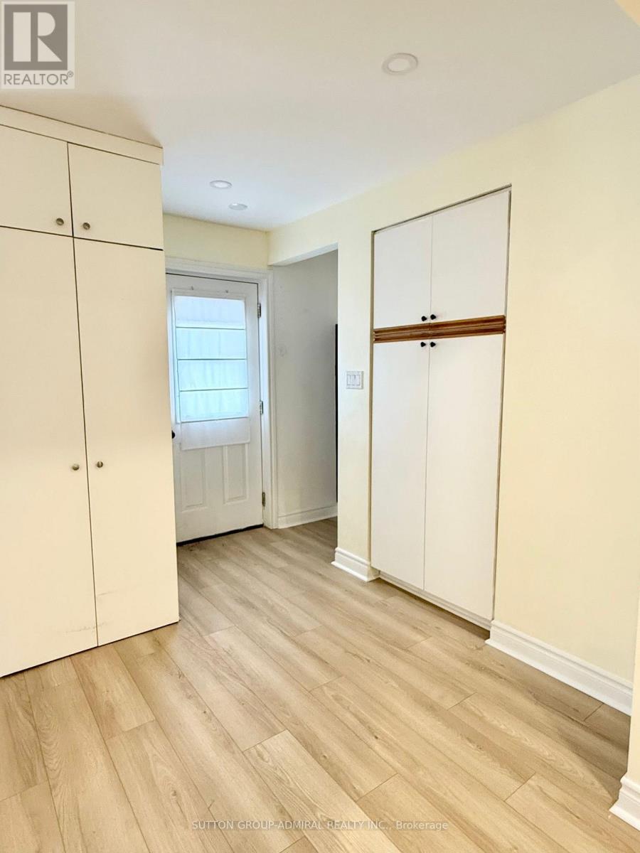 A room with a white door and a wooden floor.