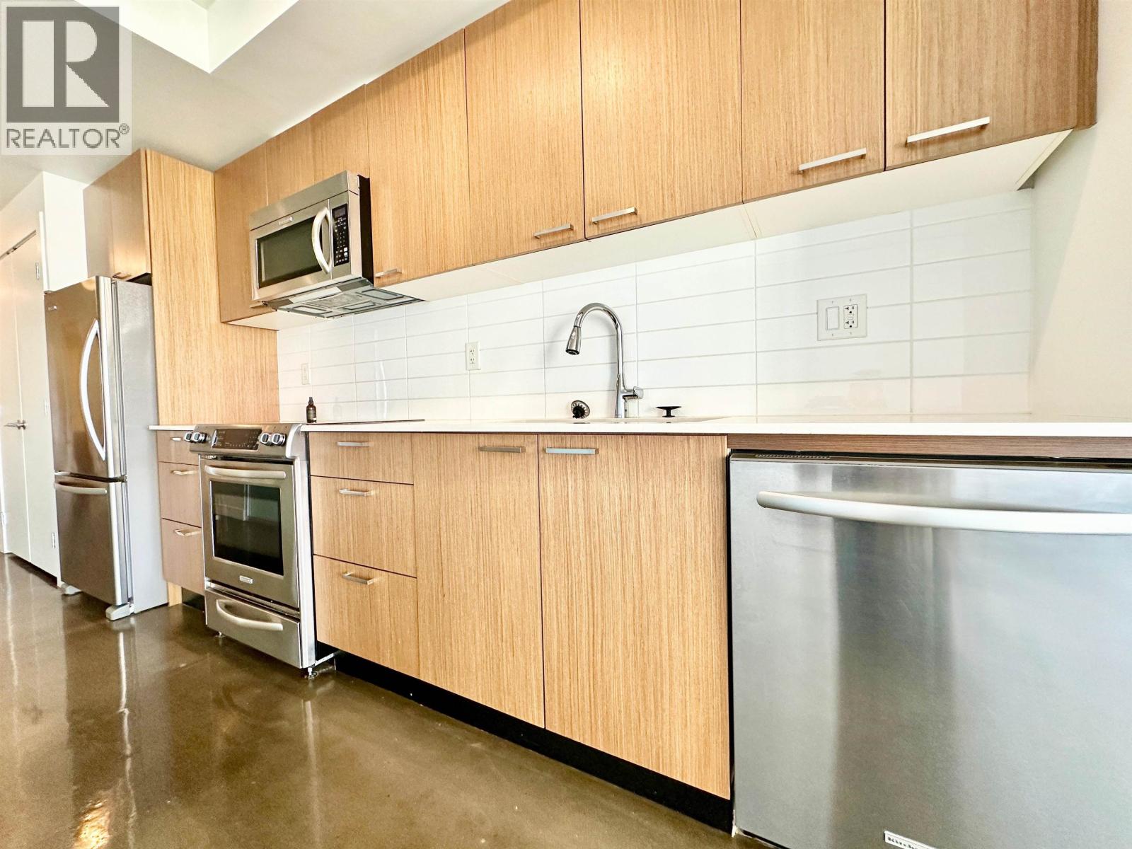 A kitchen with wooden cabinets and stainless steel appliances.