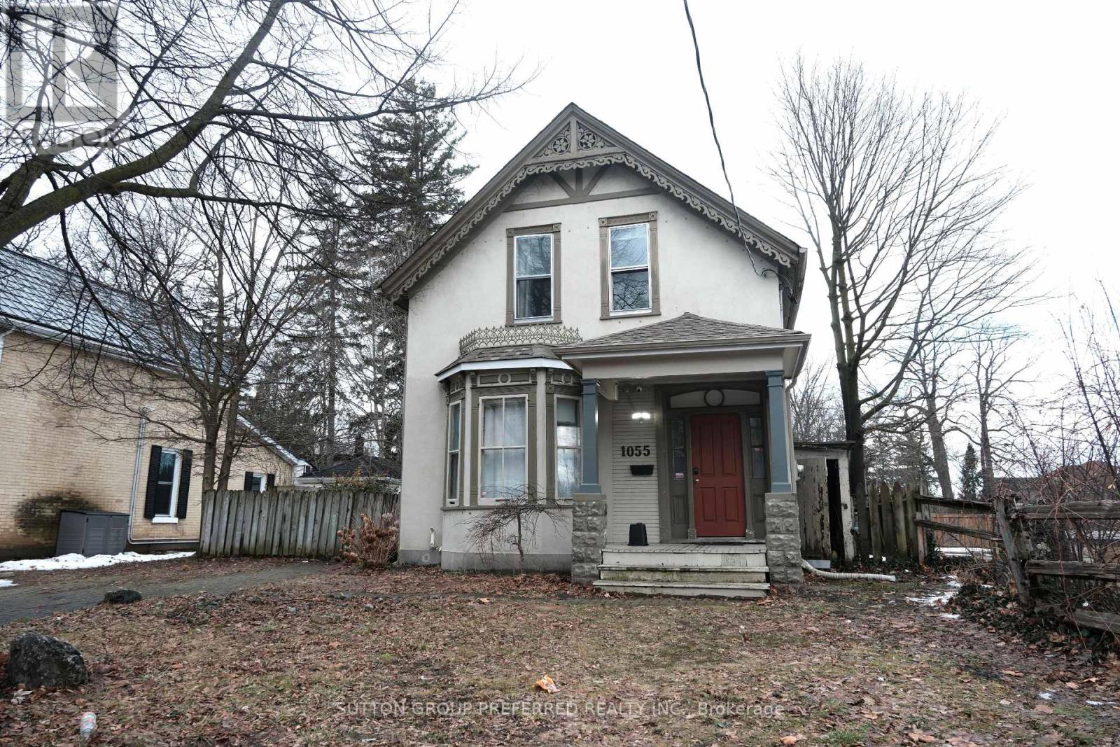 A two-story house with a red door and a small porch.