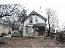 A two-story house with a red door and a small porch.