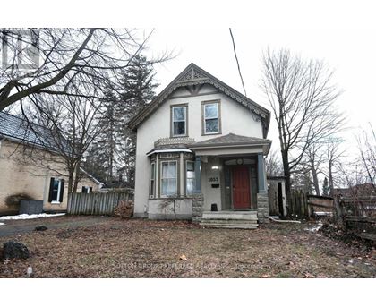 A two-story house with a red door and a small porch.
