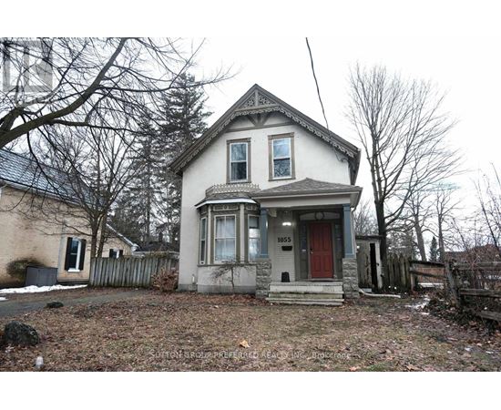A two-story house with a red door and a small porch.