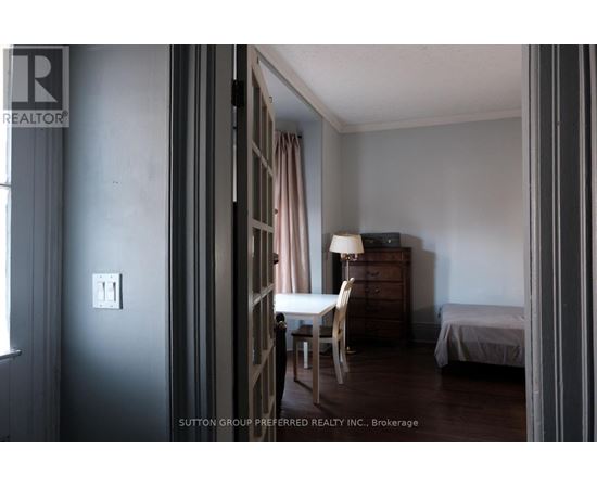 A room with a bed, a chair, and a dresser.