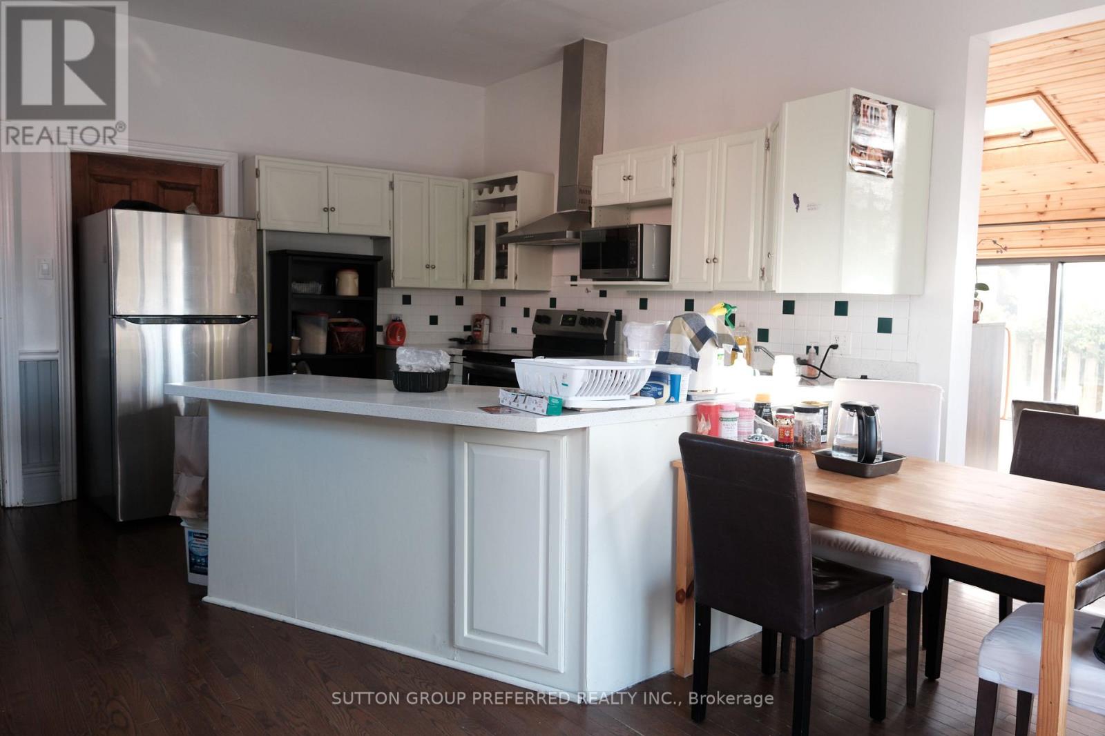 A kitchen with white cabinets and a wooden table.
