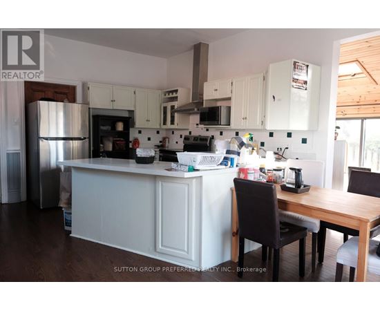 A kitchen with white cabinets and a wooden table.