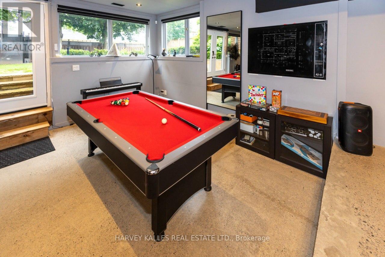A pool table in a room with a TV and a speaker.