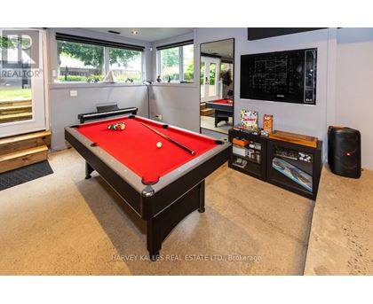 A pool table in a room with a TV and a speaker.