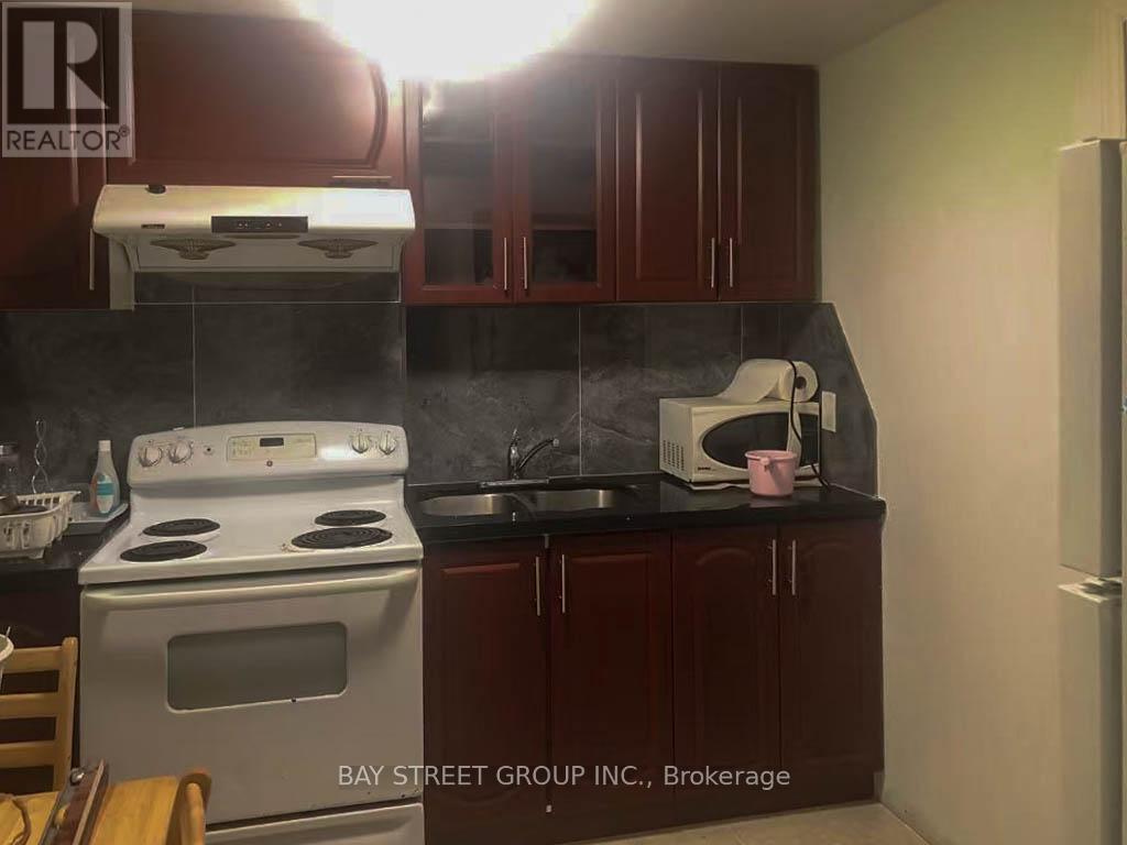 A kitchen with a white stove and dark brown cabinets.