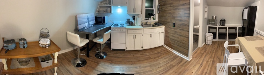 A kitchen with white cabinets and a wooden floor.