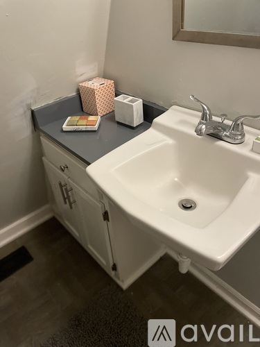 A bathroom sink with a white counter top and a silver faucet.