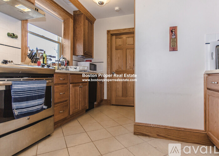 A kitchen with wooden cabinets and a white stove top oven.