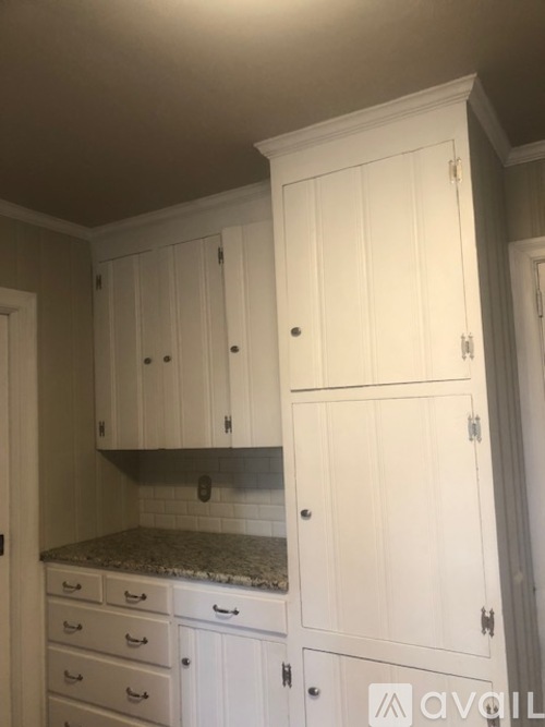A kitchen with white cabinets and drawers.