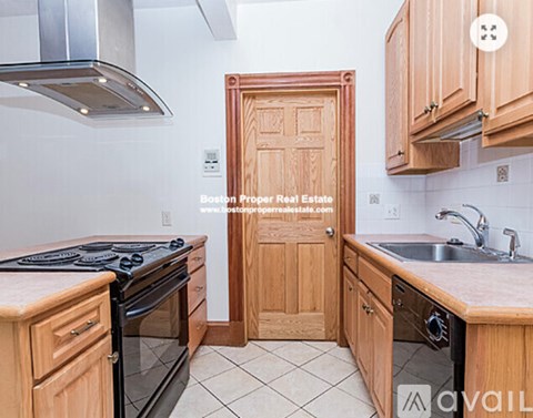 A kitchen with wooden cabinets and a stove top oven.