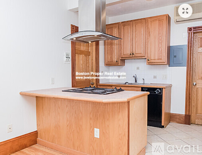 A kitchen with wooden cabinets and a stove top oven.