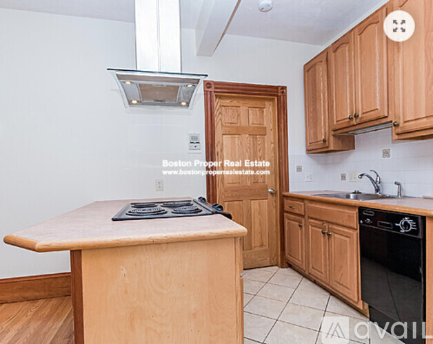 A kitchen with wooden cabinets and a stove top oven.
