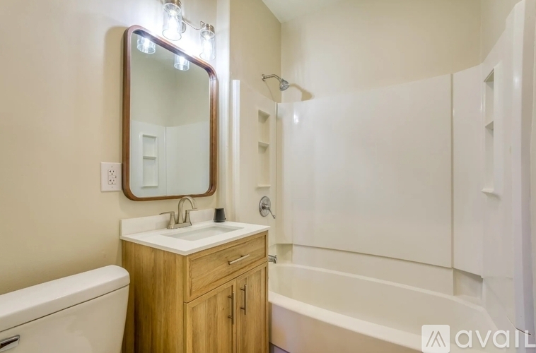 A bathroom with a wooden vanity and a white bathtub.