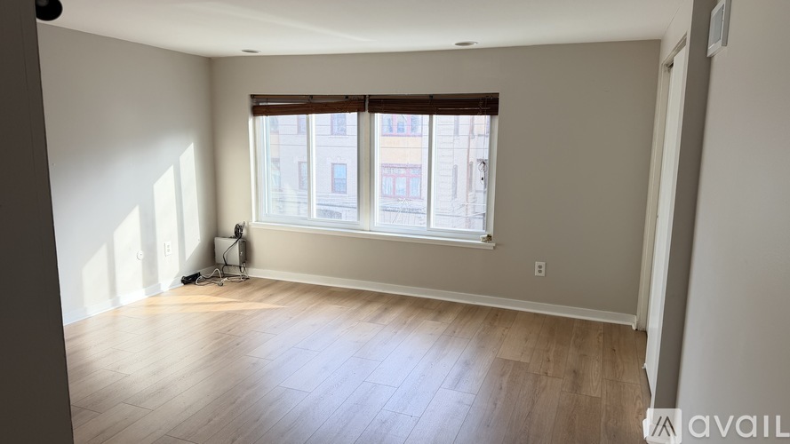 A room with a window and a wooden floor.
