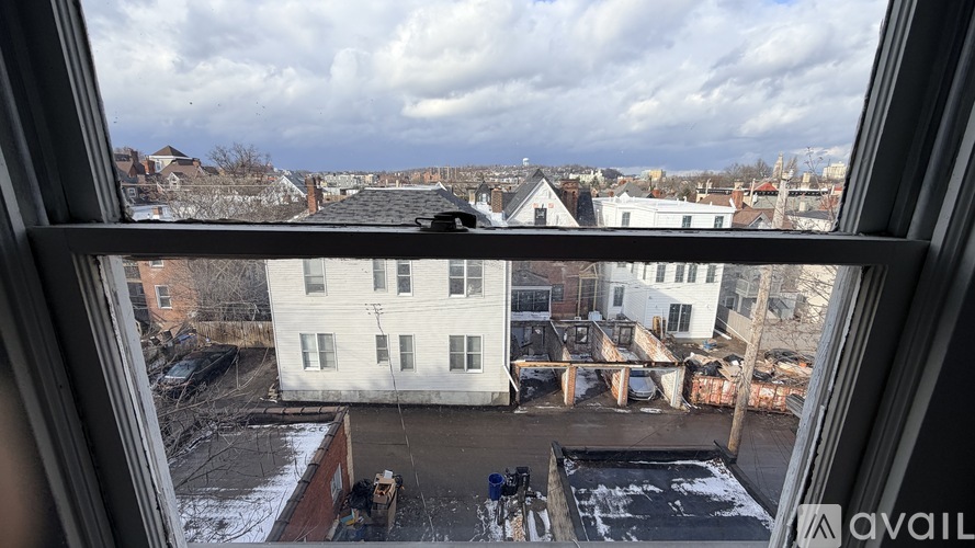 A view from a window looking out at a snowy landscape and buildings.