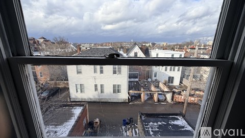 A view from a window looking out at a snowy landscape and buildings.
