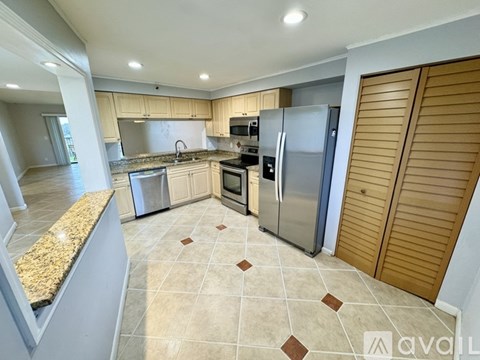 A kitchen with granite countertops and wooden cabinets.