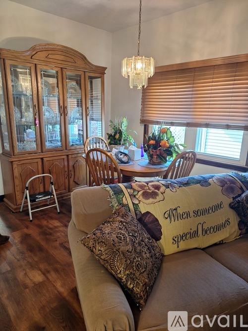 A living room with a couch and a china cabinet.