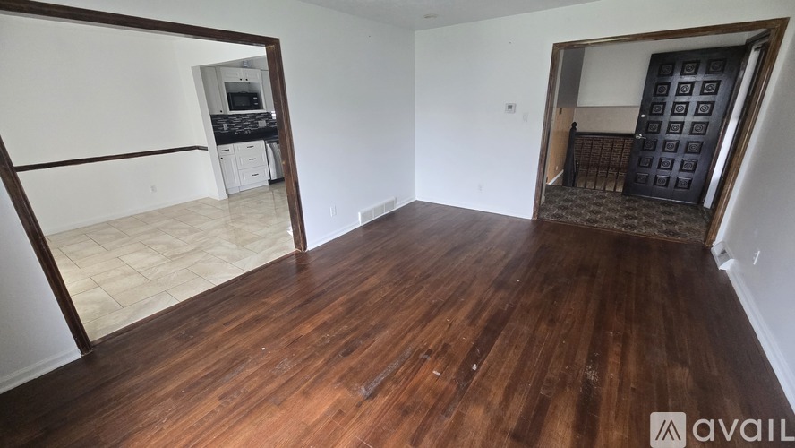 A room with wooden flooring and a mirror on the wall.