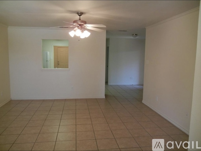 A room with a ceiling fan and tiled flooring.