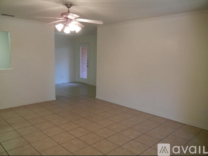 A room with a ceiling fan and tile flooring.