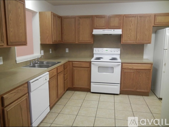 A kitchen with wooden cabinets and white appliances.