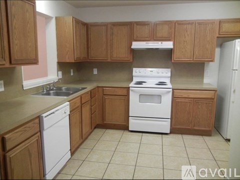 A kitchen with wooden cabinets and white appliances.