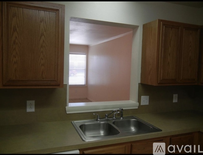 A kitchen with a sink and wooden cabinets.