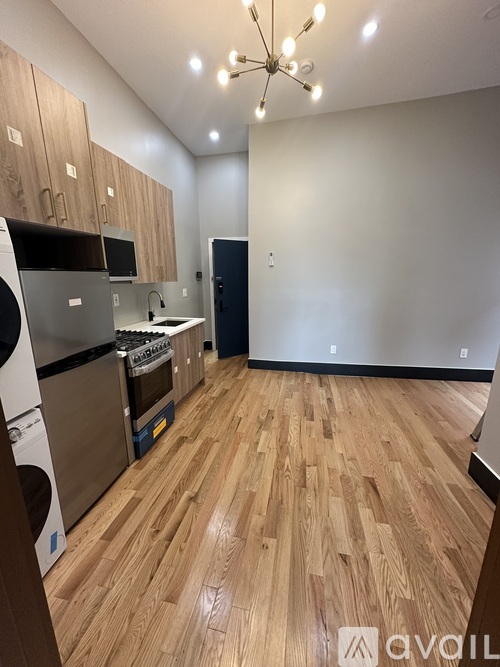 A kitchen with wooden floors and a stainless steel refrigerator.