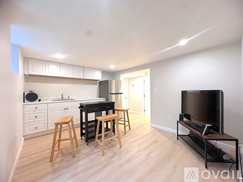 A kitchen with a dining table and chairs in the middle of the room.