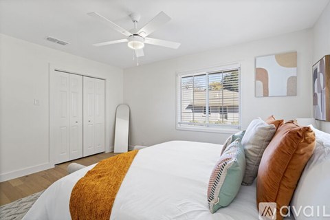 A bedroom with a large bed and a ceiling fan.